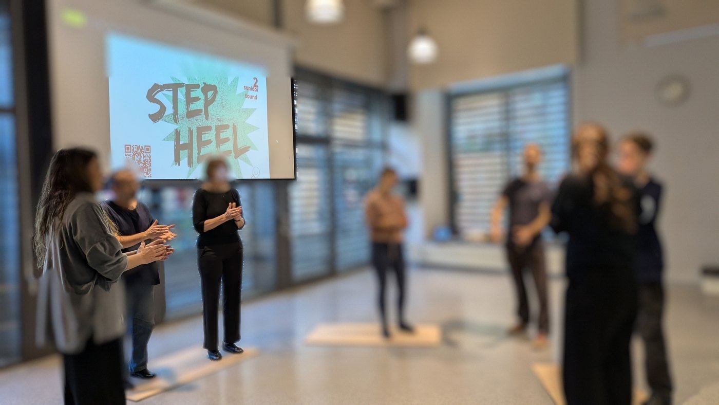 Equipo de trabajo en un taller de ritmo en una sala con el paso Step Heel proyectado