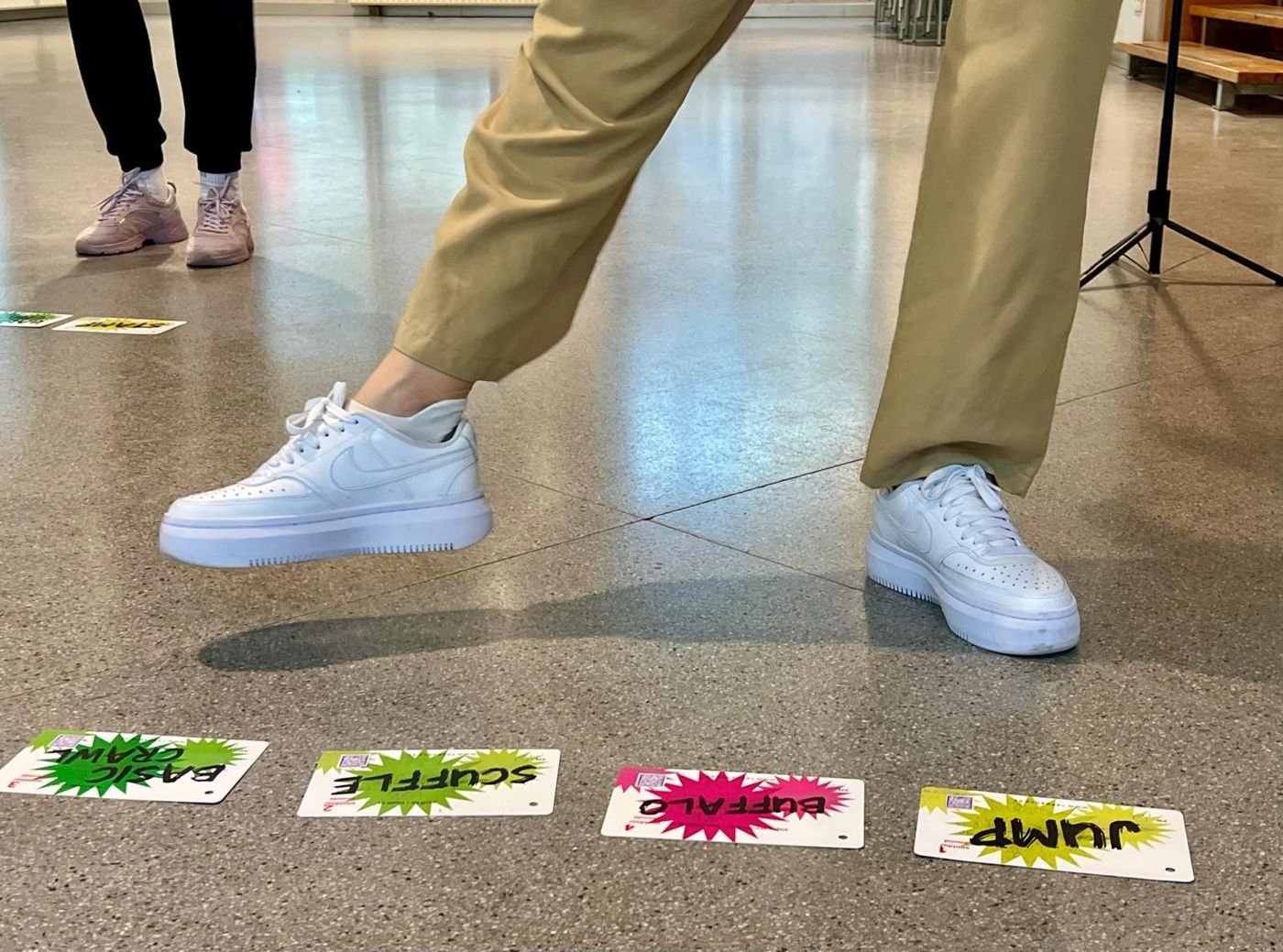 Zapatillas de calle junto a tarjetas de pasos en el suelo